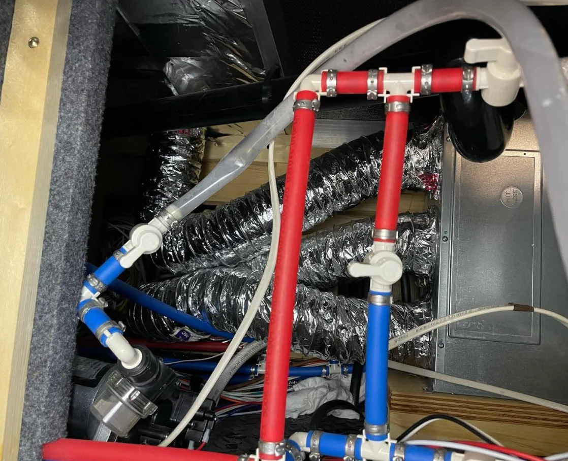 Freeze-burst PEX line downstream of an RV water pump showing winter damage